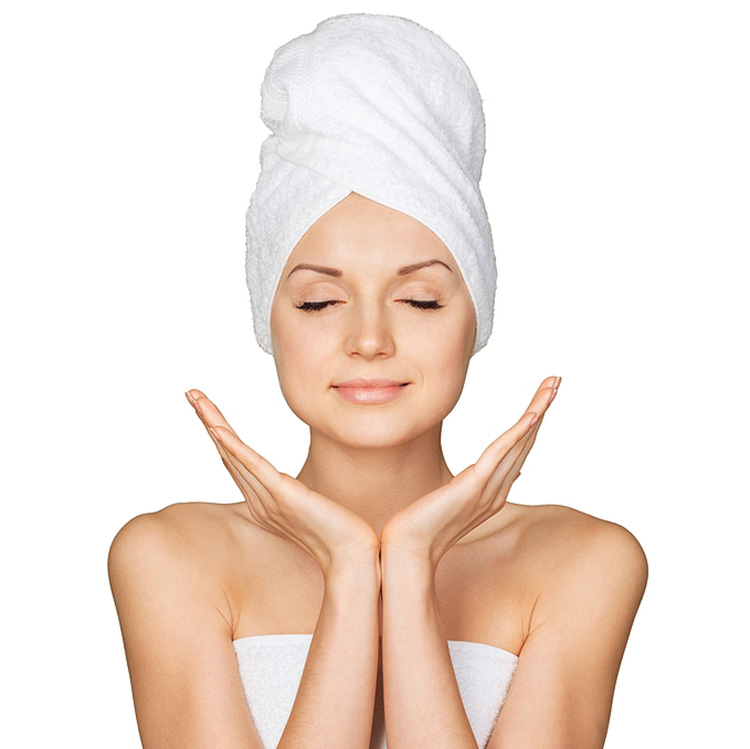 Photo of woman with towel wrapped on her head and her demontstrating clean skin